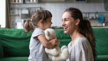 a toddler activities with stuffed animals, girl hugs stuffed animal she found while her mom laughs