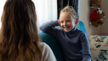 young girl talking to therapist on a couch
