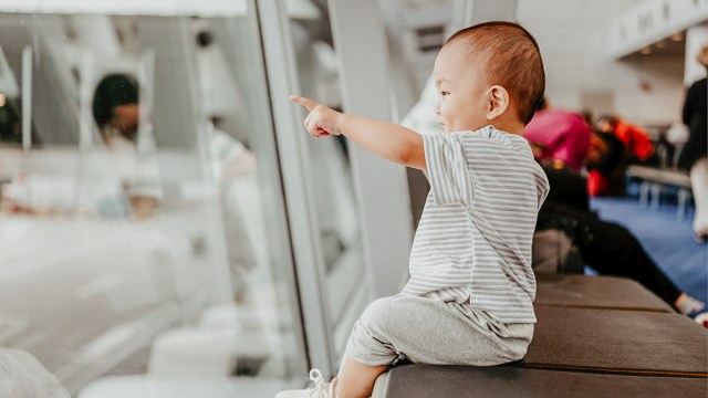 A baby at the airport looking at the airplanes for a story on TikTok travel hacks for babies