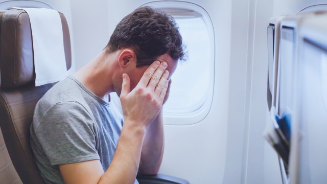 man stressed out on plane after being covered in glitter by child