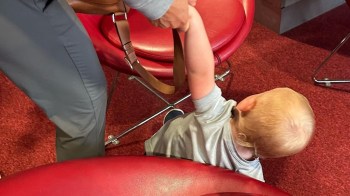 Dylan Dreyer's son lays on the floor while someone tries to pick him up.