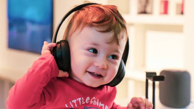 Smiling baby with headphones on in front of a microphone