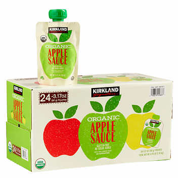 A box of 24 packets of Kirkland organic apple sauce with one packet standing on top of the box for a story on packaged Costco snacks