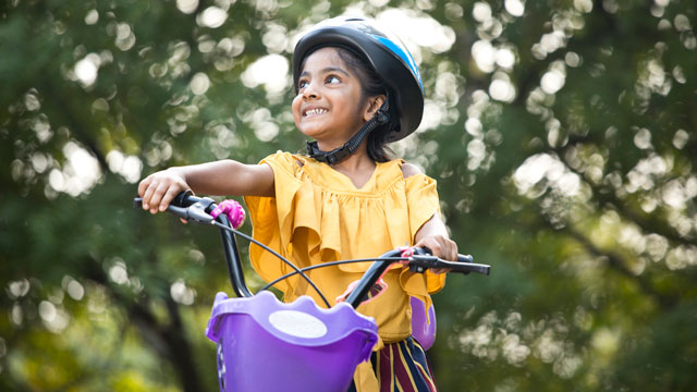 little girl riding a bike in the park, a summer bucket list idea