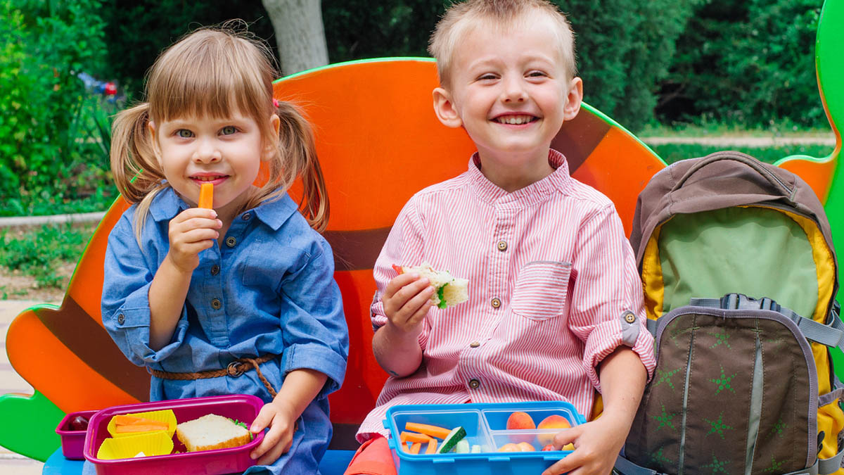 https://tinybeans.com/wp-content/uploads/2023/08/little-kids-eating-lunch-outside-energizing-lunch-box-how-to.jpg