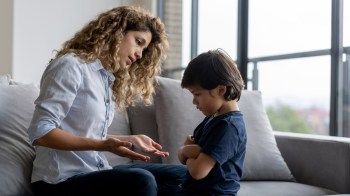 a mom having a serious conversation with her young son for a story on phrases that secretly undermine your kids confidence