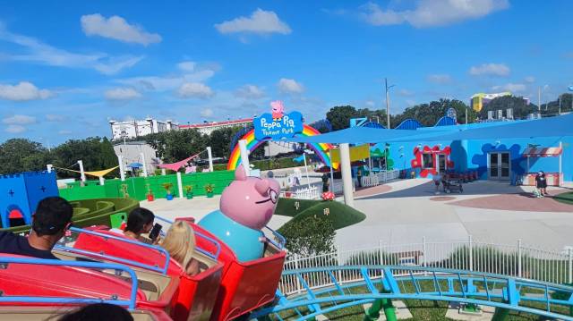 ariel view of Peppa Pig Theme Park from roller coaster with Daddy Pig in front seat