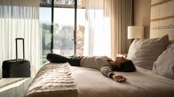 woman lying in a hotel bed on a solo trip