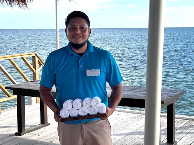 Employee at Margaritaville Beach Resort Ambergris Caye greeting guests with cold towels