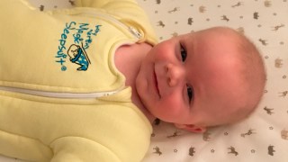a close up of a baby in a baby merlin's magic sleepsuit