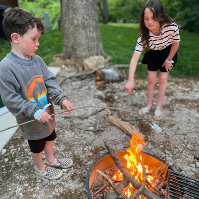 kids making s'mores over a campfire at jellystone camp resort lodi