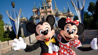 mickey and minnie mouse in front of castle at Disneyland
