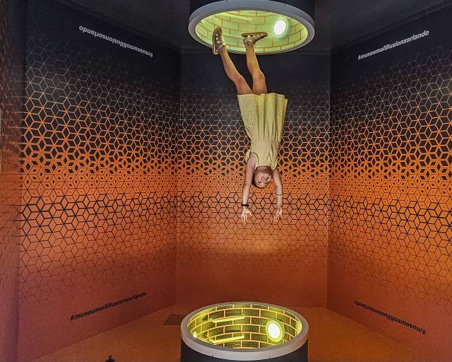 girl falling out of a portal from the ceiling at Museum of Illusions in Orlando, Florida