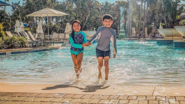 A boy and a girl walking out of the pool at Hilton Orlando in Orlando, Florida