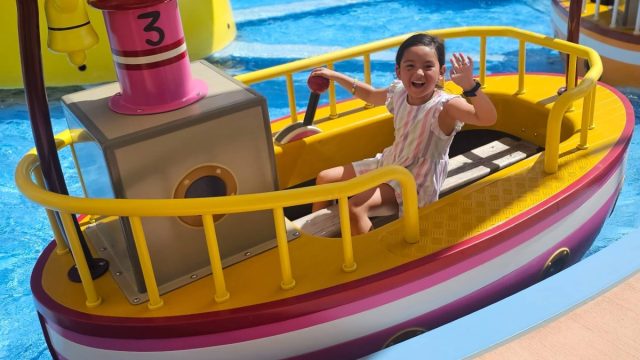 little girl waving from boat ride at Peppa Pig Theme Park in Orlando, Florida