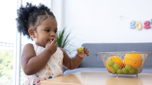 a toddler about to eat a whole grape, which is a choking hazard