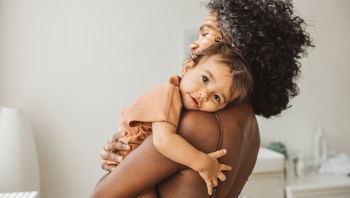 a mother cuddling her baby for a story on how to stop breastfeeding