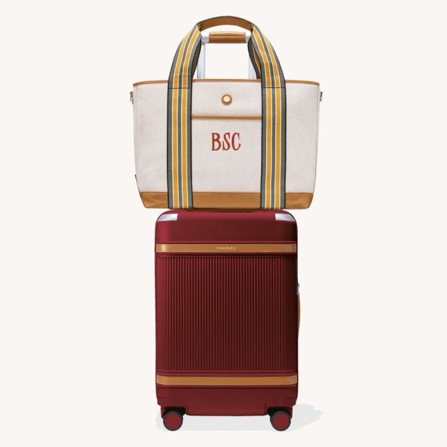 set of red carry on luggage and tote bag