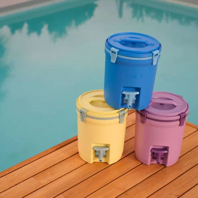 three stanley water jugs on a poolside duck