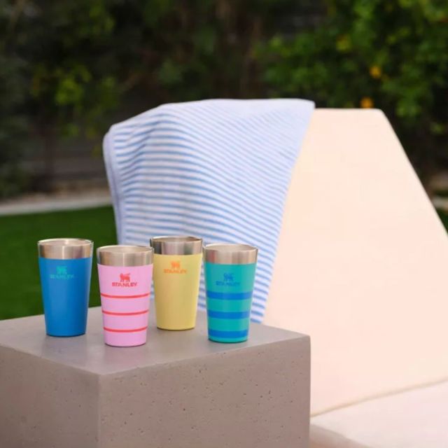4 stanley pint cups next to a pool lounge chair