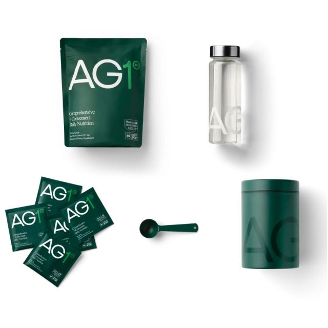bottle of AG1 supplements, canister, packets, scoop, and bottle