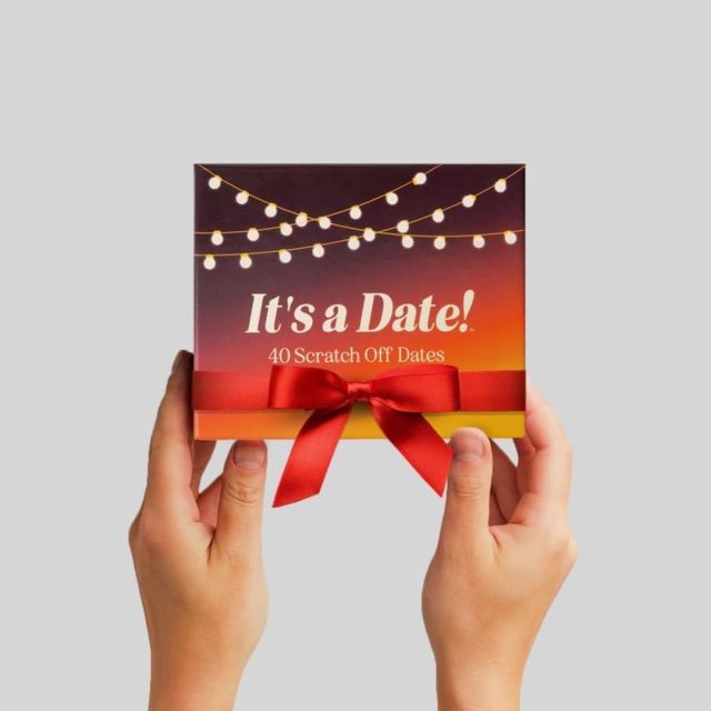 hands holding up a box of It's a Date scratch off card game