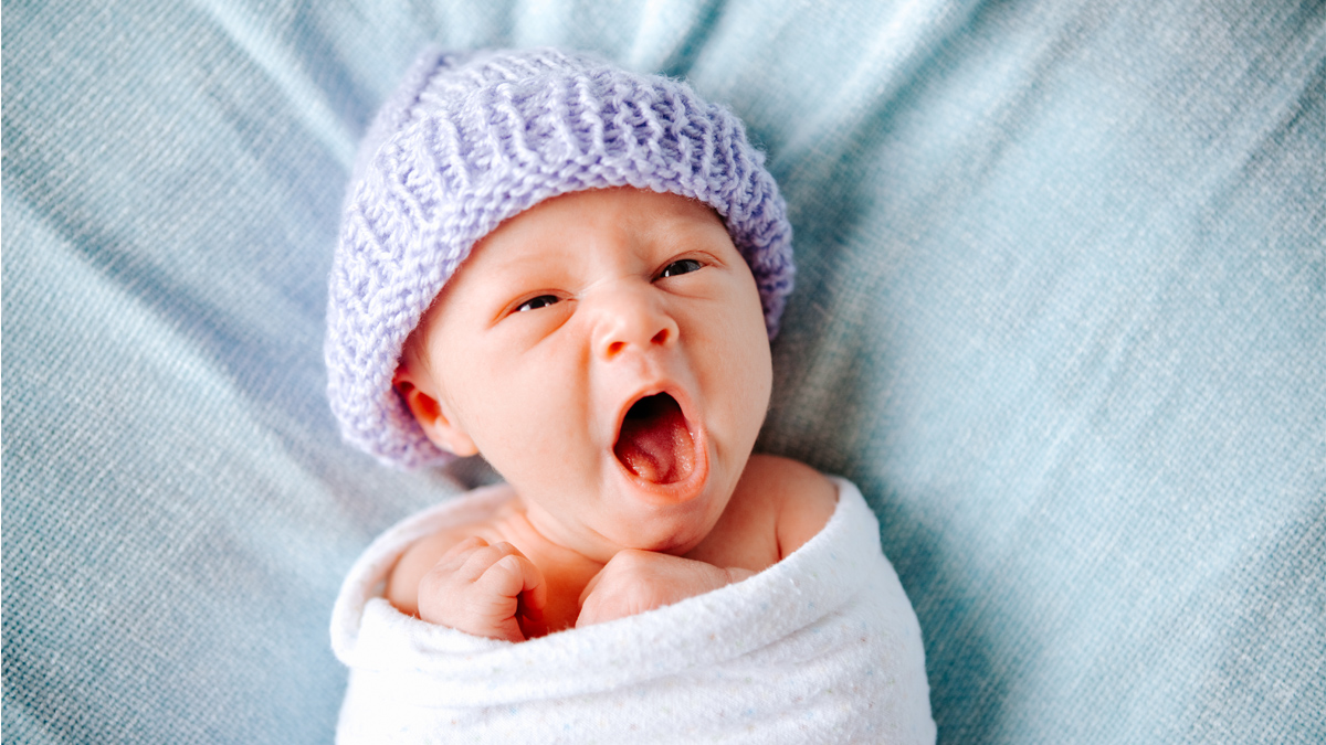 a newborn baby in a beanie for a story on weird baby facts