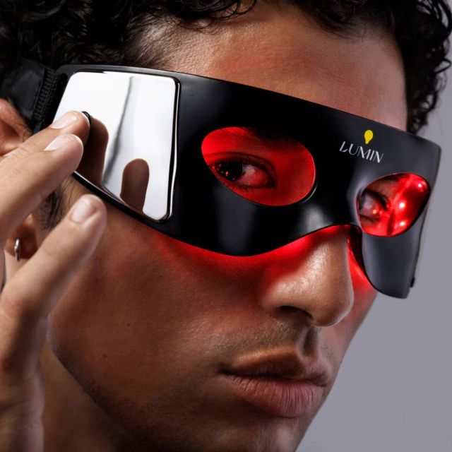 man wearing a red light therapy eye mask