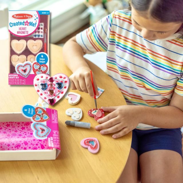 girl playing with a heart-themed craft