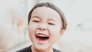 a little kid laughing at one of our jokes for toddlers