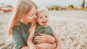 mom on the beach posing with toddler sticking her tongue out, an adorable family photo idea