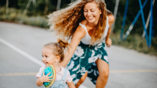 a mother running after her toddler, which is one of the best family photo ideas with toddlers