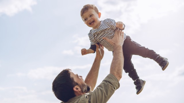 A toddler getting an airplane ride from his dad, one of our fun family photo ideas