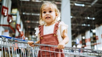 toddler girl in grocery store cart
