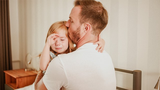 dad at bedtime comforting daughter who has nighttime fears