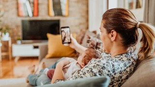 mom FaceTiming relatives with baby on her lap
