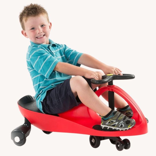 little boy riding a red ride-on PlasmaCar toy