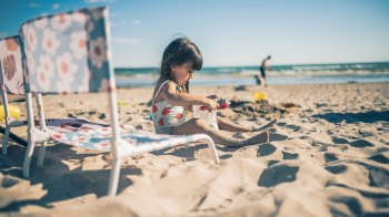 toddler girl playing on beach during a backwards beach day