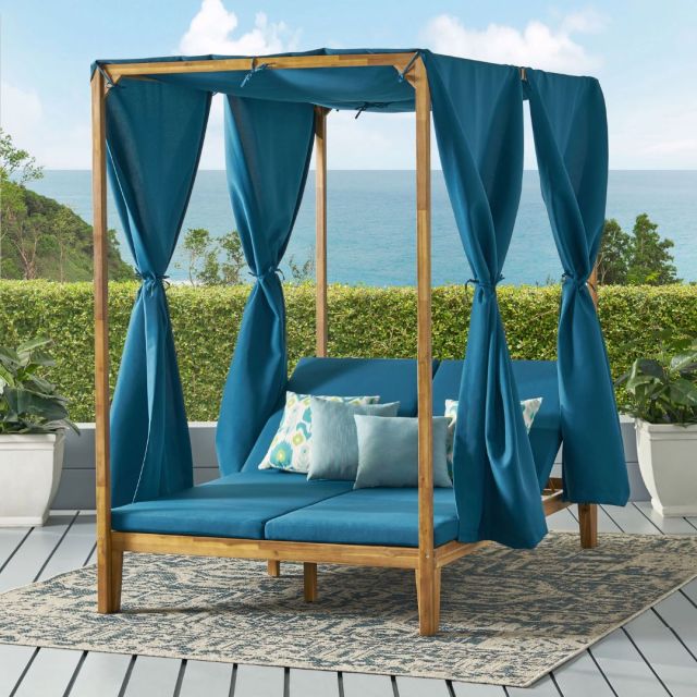 acacia 4 post outdoor day bed with teal cushions and curtains