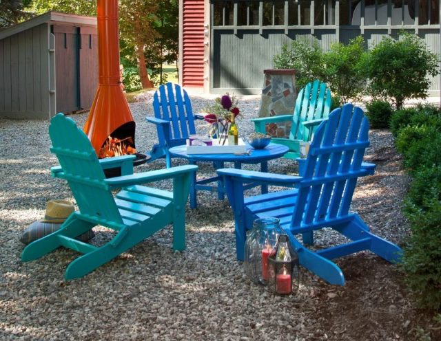 set of 4 adirondack chairs and matching table in backyard