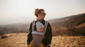 a mom babywearing her baby while on a hike