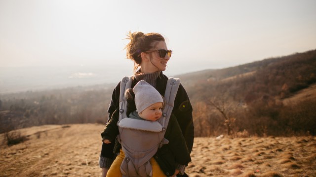 a mom babywearing her baby while on a hike