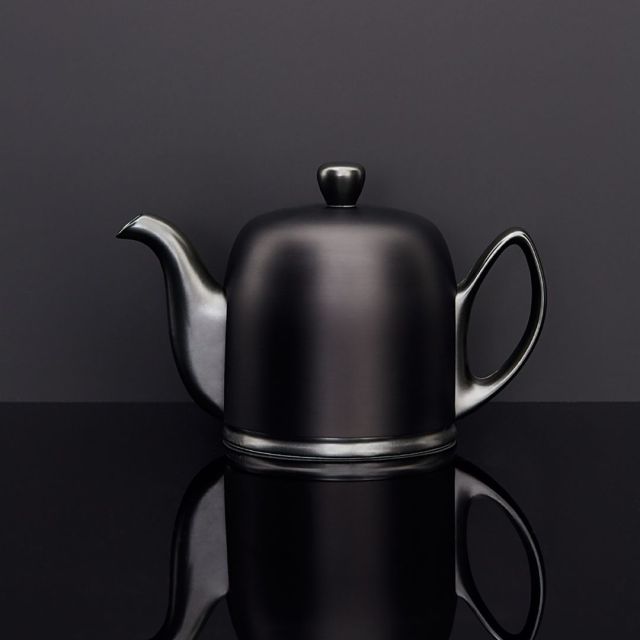 matte black teapot on black surface against black background