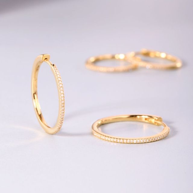 two pairs of thing gold hoop earrings with pavé diamonds