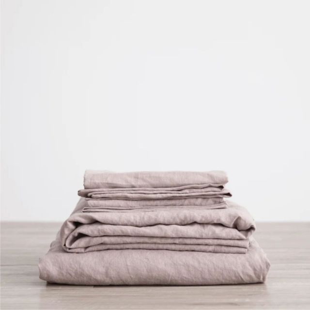 stack of folded linen sheets in dusky purple