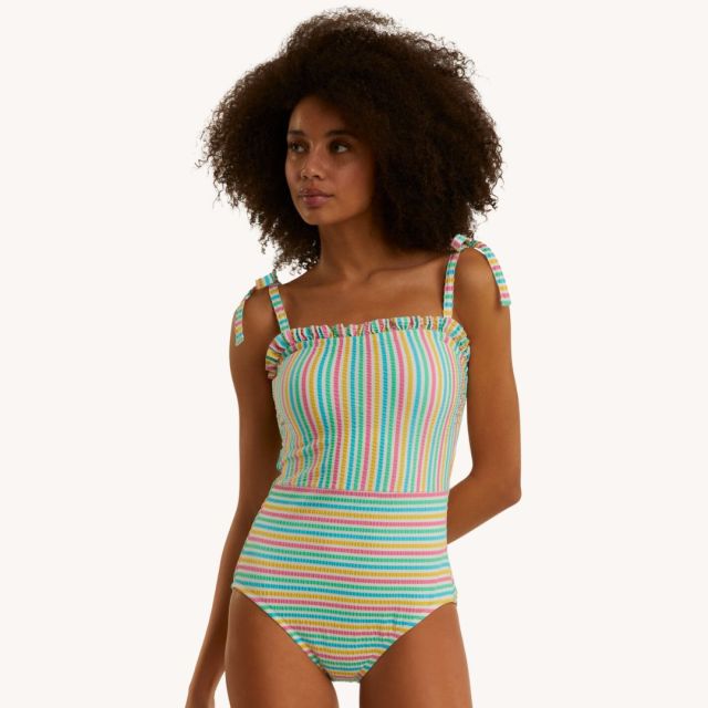 woman standing in striped retro ruffle swimsuit