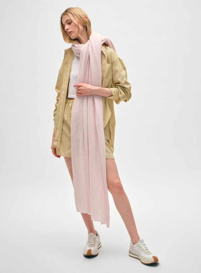 woman wearing a long cashmere travel wrap in light pink