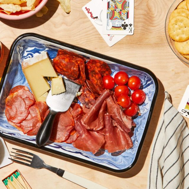 charcuterie board surrounded by playing cards