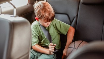 picture of a boy buckling his seatbelt in the school pickup line