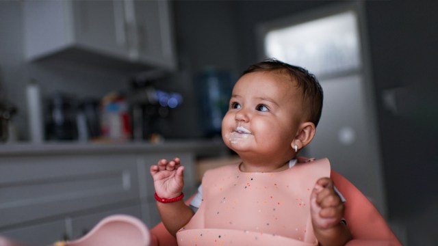 a baby girl eating some yogurt for a collection of tips for starting solids